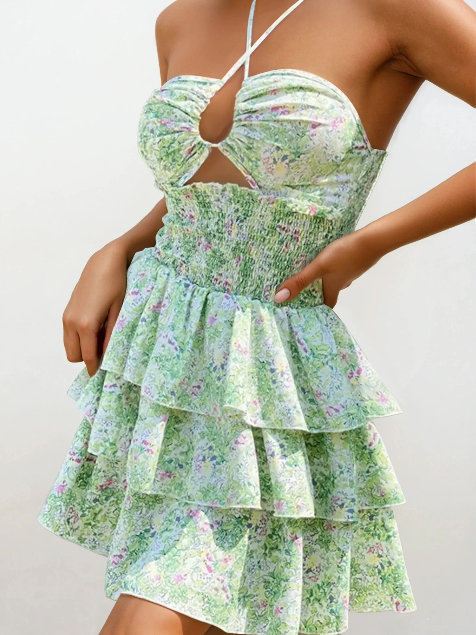 Light floral halter neck mini dress with cutout and ruffle details, stylish clothing by Trendsi featuring a trendy design.