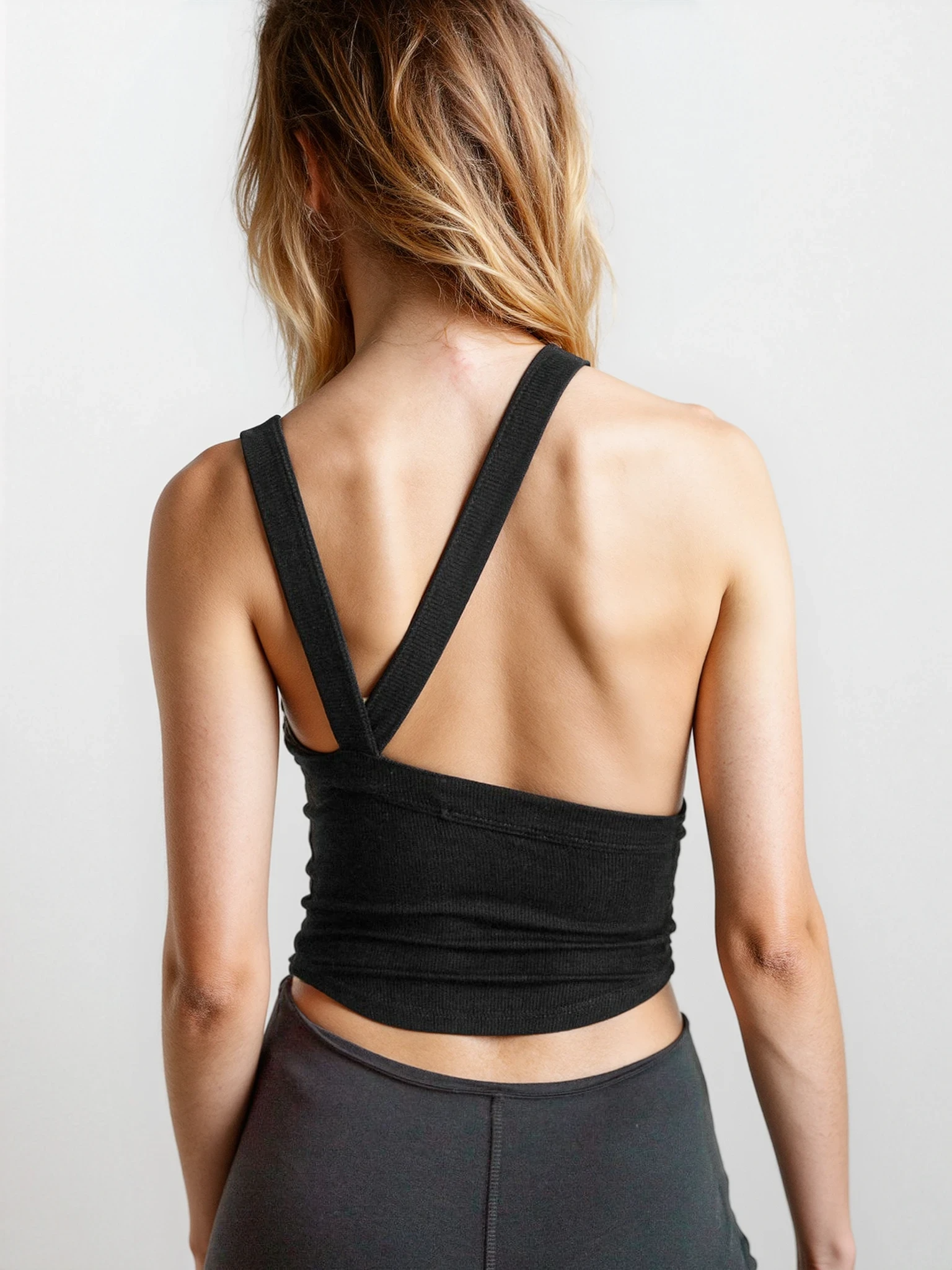 Light gray rib-knit halter neck sleeveless cropped tank top from Trendsi, featuring a fitted halter style and casual sleeveless design.