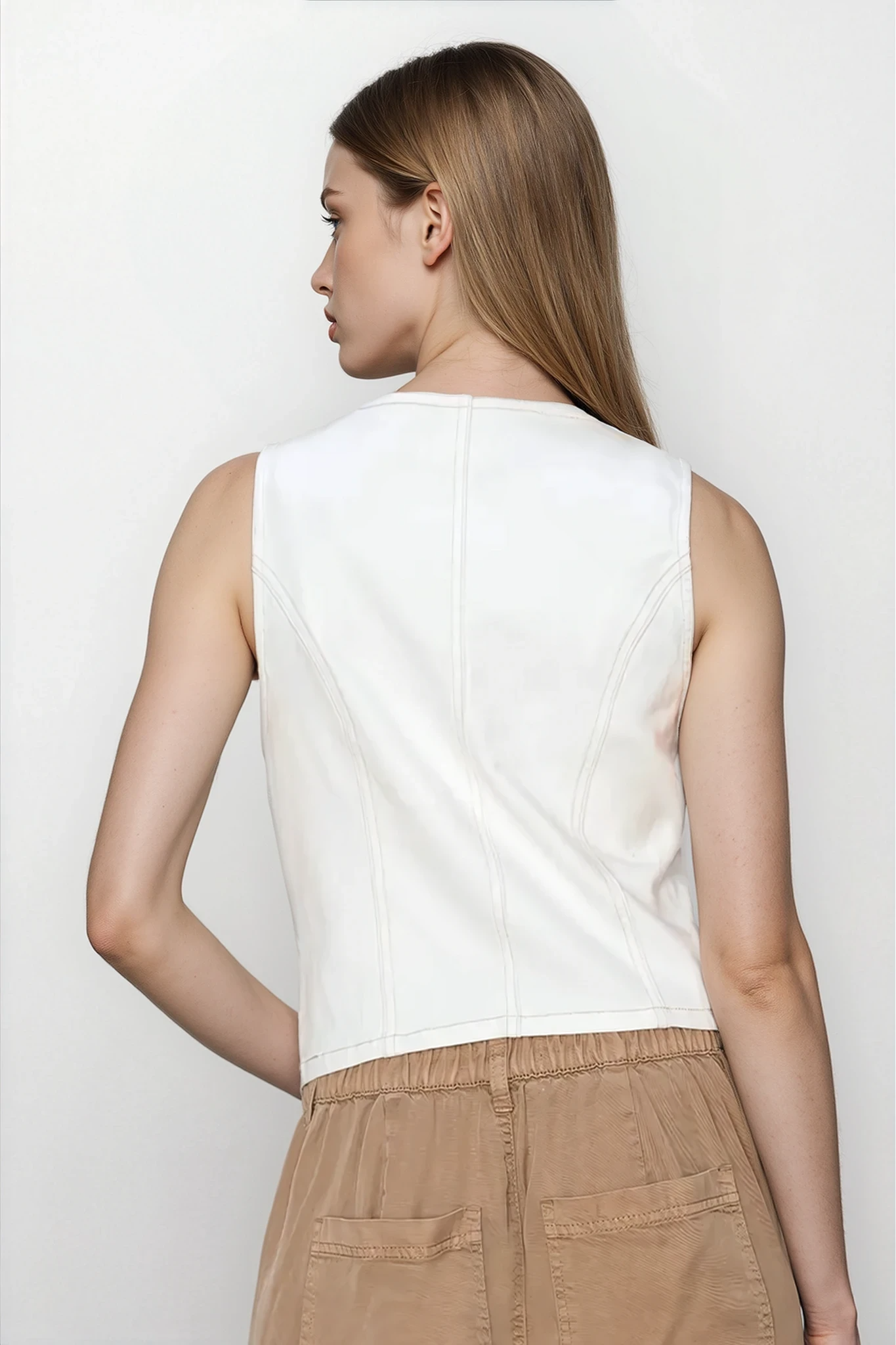Marlo V-Neck Cropped Vest from Trendsi, light-colored sleeveless clothing with a V-neck design, shown on a model.