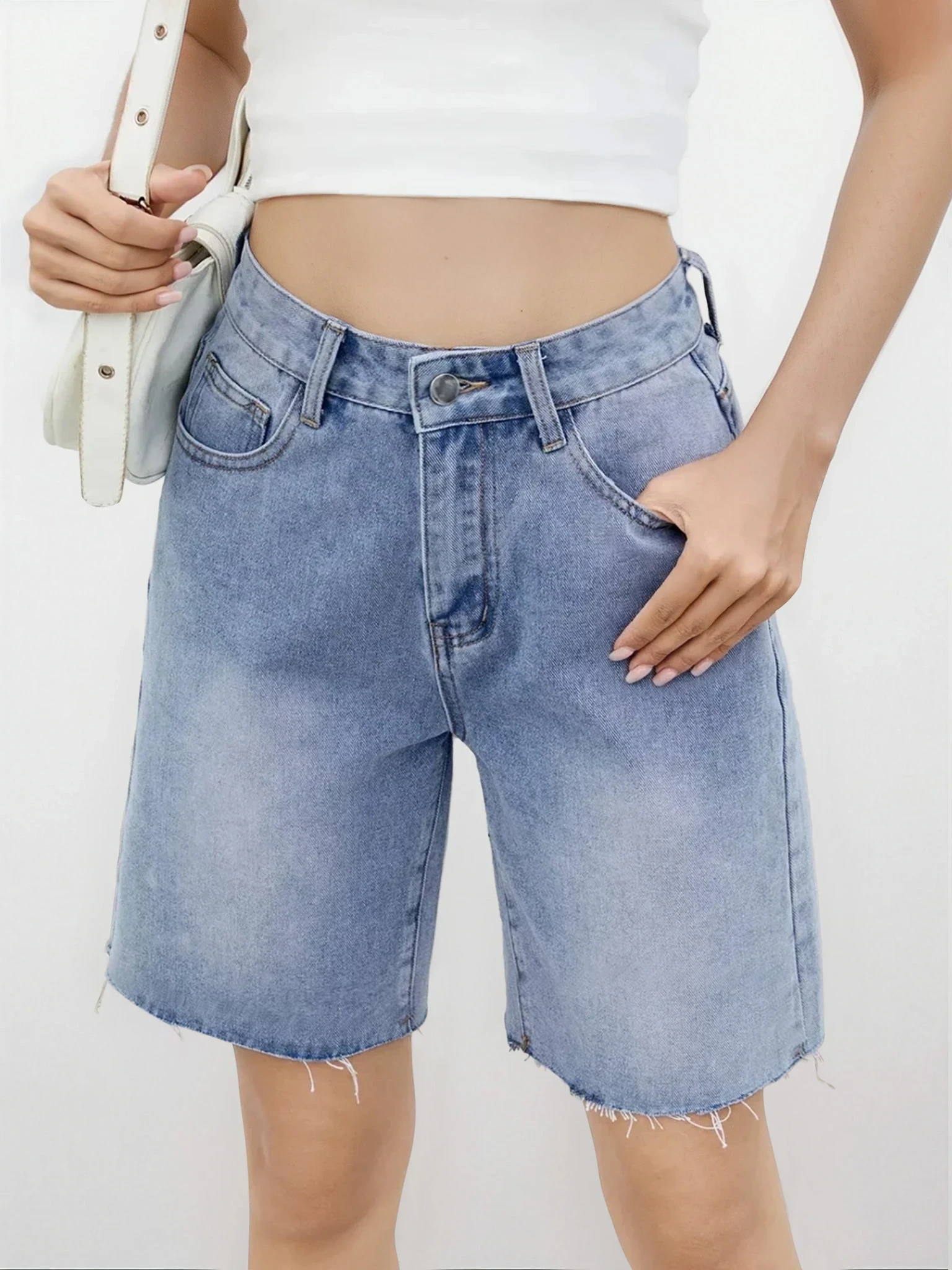 Light studio image of Rogue Raw Hem Denim Shorts by Trendsi, showcasing casual denim shorts with distressed raw hems.
